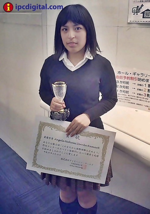 La peruana Ángela Zorrila, primer lugar del concurso de redacción de HICE, sostiene la COPA IPC y su diploma.