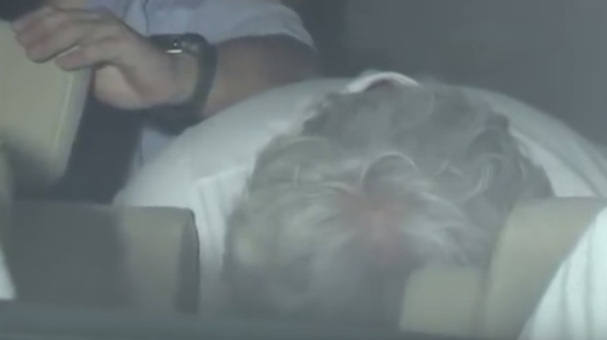 Estafador se esconde mientras es llevado por la policía